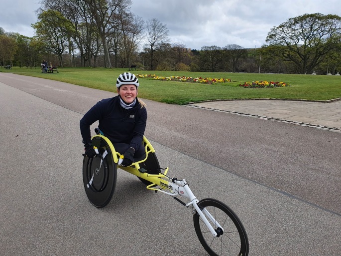 Joanna smiling on her handcycle at Duthie Park.